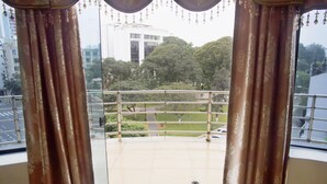 Un balcón con vistas a un edificio y árboles.