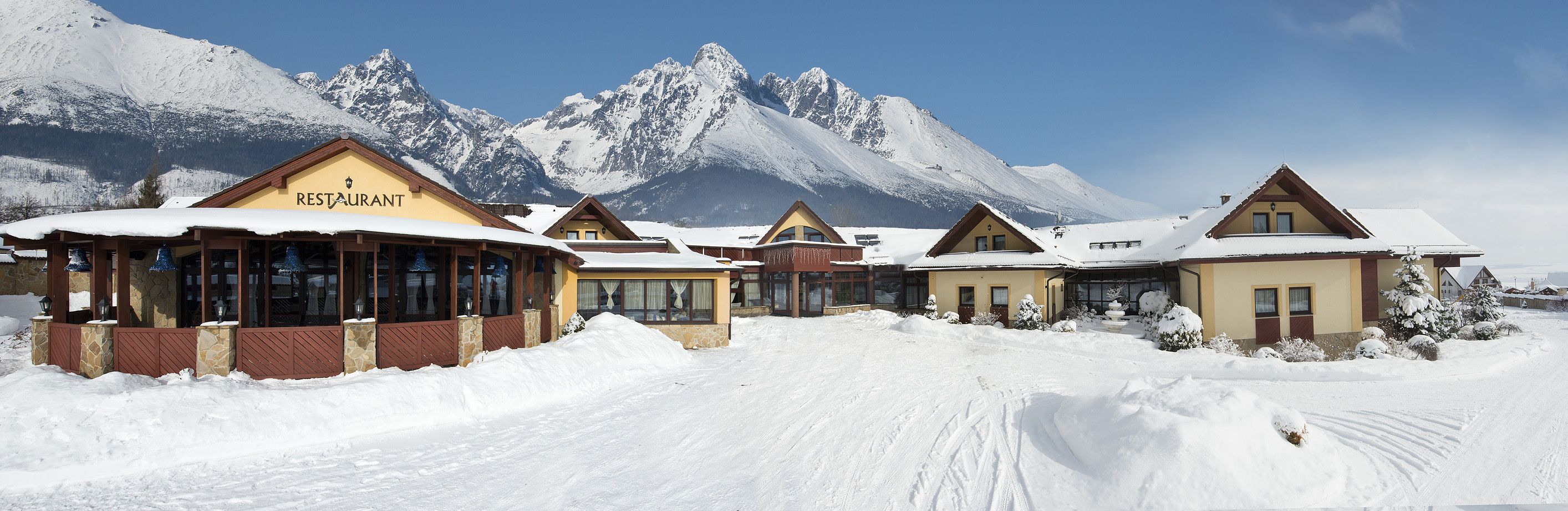 Estância de esqui coberta de neve, com restaurante e vários edifícios em estilo chalé.