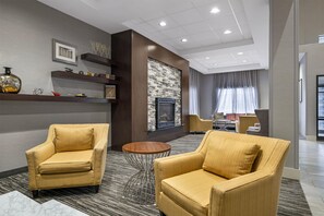 A modern living room with two armchairs, a fireplace, and a stone accent wall. - Best Western Plus The Hammondsport Hotel (Hammondsport)
