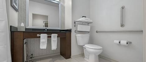 A modern bathroom with a vanity, toilet, and shower area.