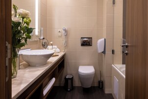 A modern bathroom with a large sink, toilet, and shower.