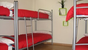 A bunk bed room with metal frames and red bedding. - Bilbao Central Hostel (Bilbao)