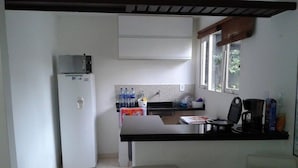 Una cocina compacta con refrigerador, lavaplatos y ventana.