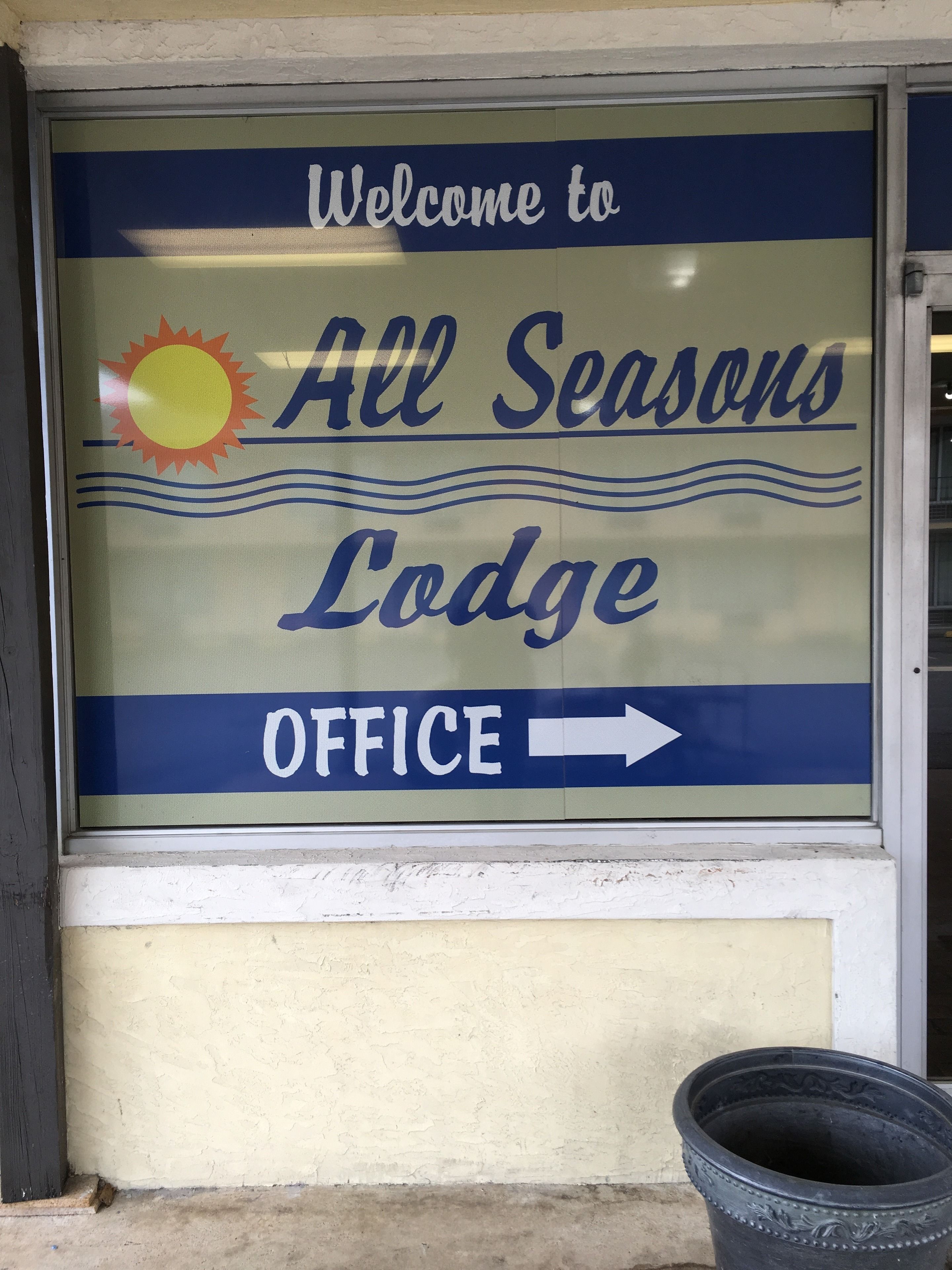 A welcome sign for All Seasons Lodge Office with directional arrows.