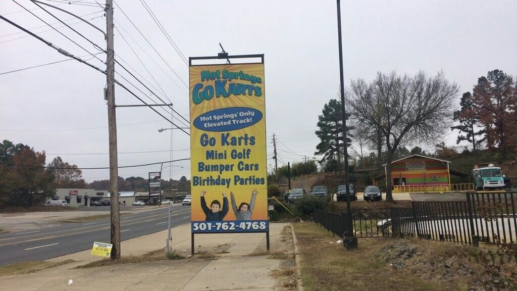 Señal de Go Karts que anuncia servicios como minigolf, autos chocones y fiestas de cumpleaños.