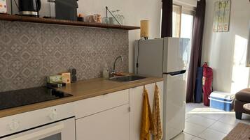A modern kitchen with a built-in oven, a refrigerator, and a sink.