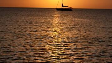 A sailboat on calm water during sunset.