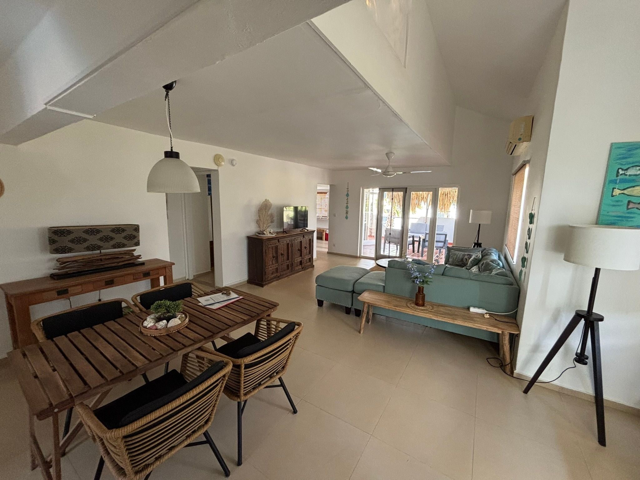 A spacious living area with a dining table, sofas, and a coffee table.
