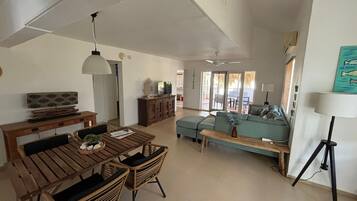 A spacious living area with a dining table, sofas, and a coffee table.