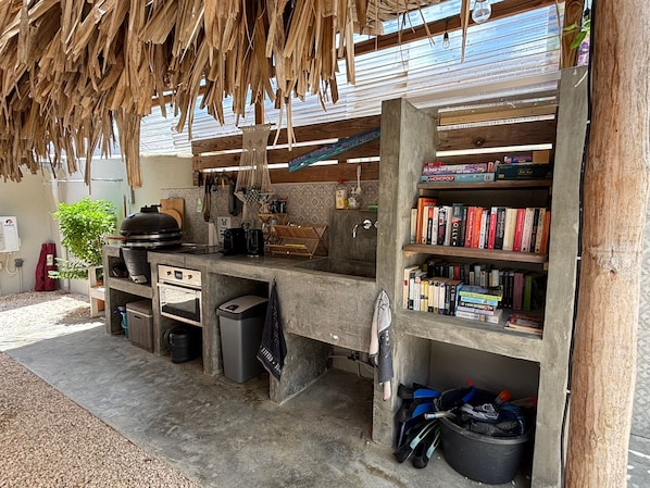 Une cuisine compacte dotée d’une bibliothèque intégrée, d’un barbecue et d’un sol en béton.