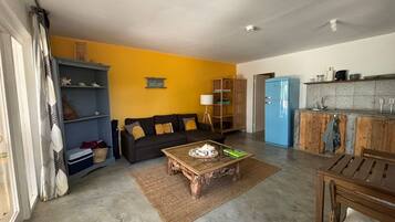 A compact living space with a sofa, coffee table, and a kitchenette area.