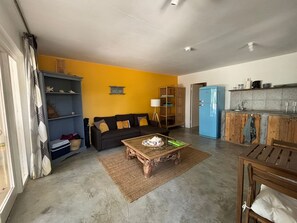 A compact living space with a sofa, coffee table, and a kitchenette area. - BnBBonaire (Kralendijk)