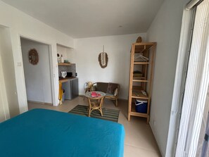 A compact room with a bed, a small table, a sofa, a kitchenette, and a wardrobe. - BnBBonaire (Kralendijk)