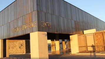 Ein modernes Gebäude mit flachem Dach und großem Eingang. Auf der Fassade sind die Worte "OTUKANGO CONFERENCE CENTRE" sichtbar.