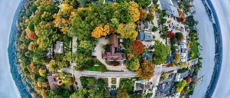 Une vue aérienne circulaire d’un quartier résidentiel, avec des maisons, des routes et une étendue d’eau.