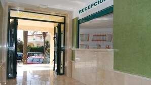 Un espace d’accueil d’hôtel comprenant un comptoir de réception et une enseigne indiquant « RÉCEPTION ».