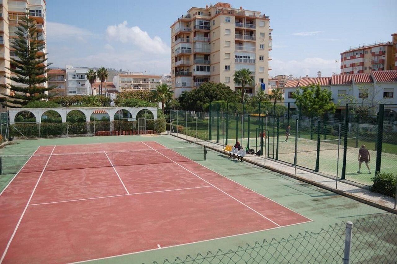 Una cancha de tenis al aire libre rodeada de edificios residenciales.