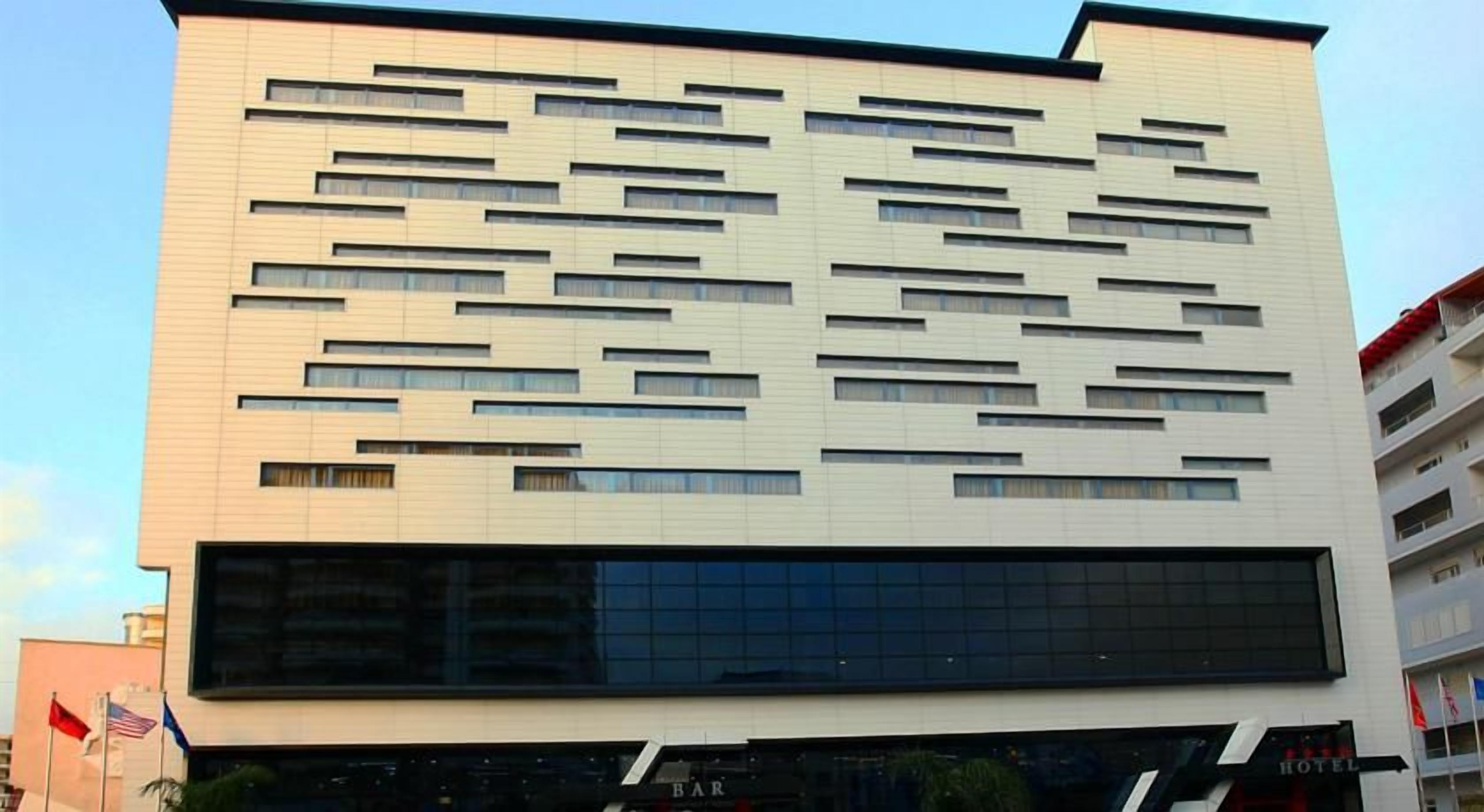 Een modern gebouw met een platte gevel, veel ramen en een grote glazen ingang.