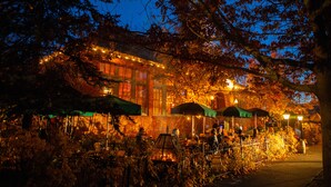 A brick building with outdoor seating and string lights. - McMenamins Old St. Francis (Bend)