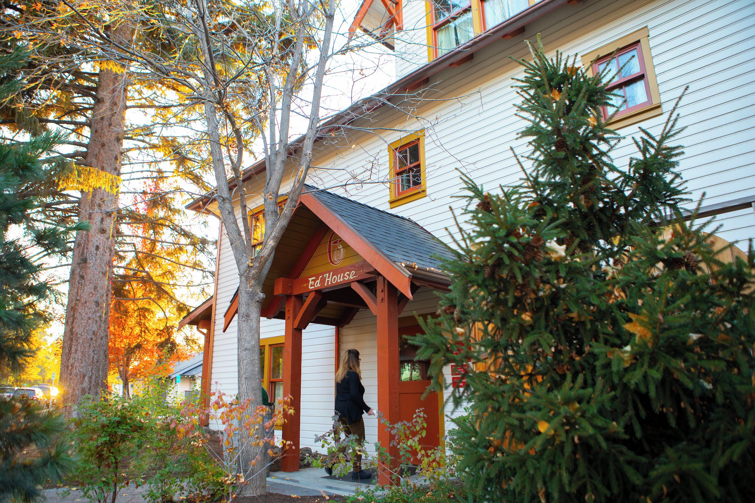 A white building with a red porch and a sign that reads 'Ed House.'