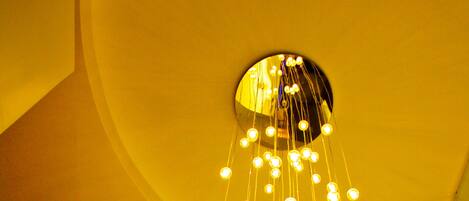 A curved staircase with a modern light fixture at the top.
