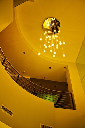 A curved staircase with a modern light fixture at the top.
