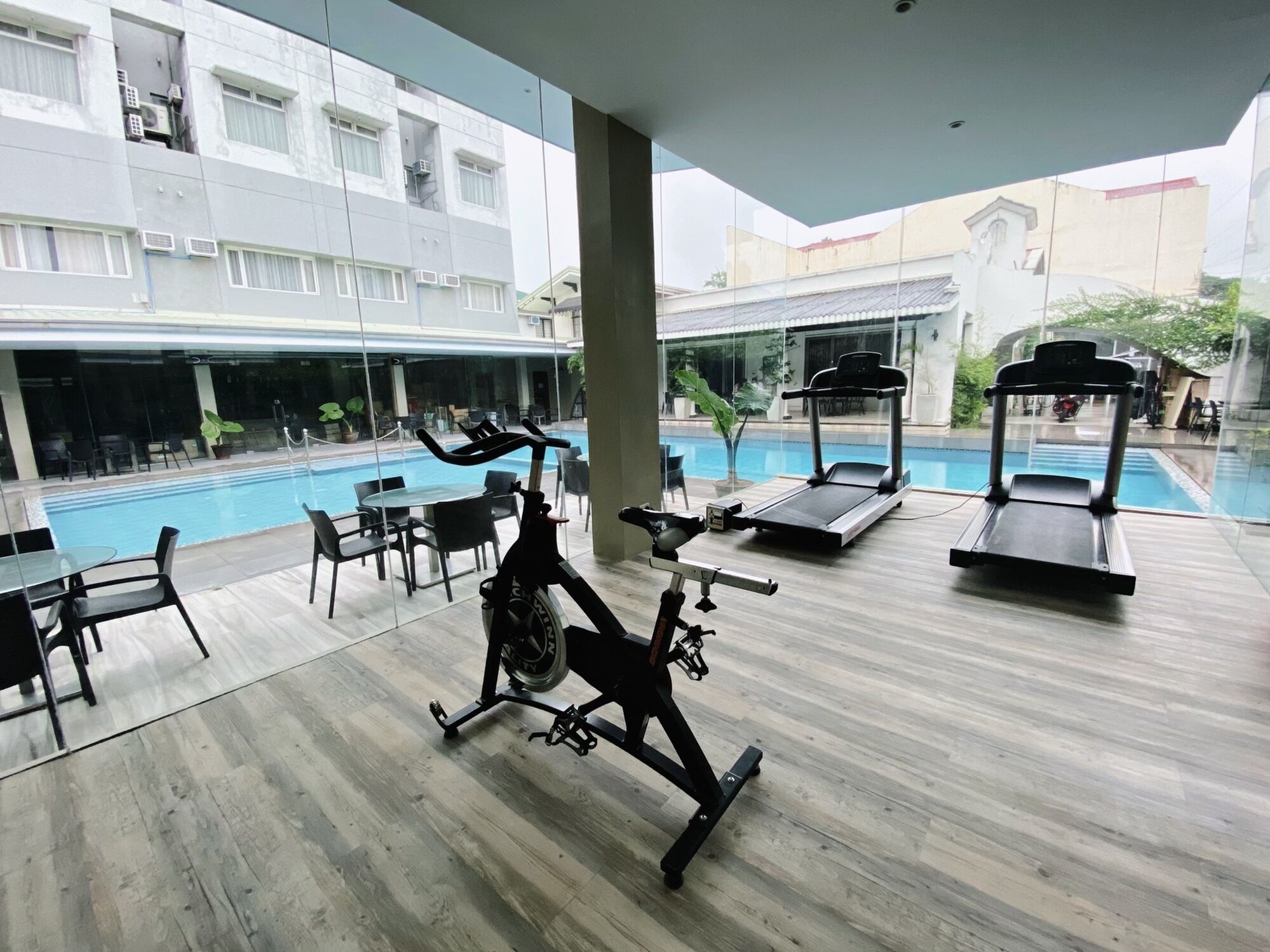 Un espace de remise en forme équipé de matériel d’exercice, une piscine et un espace de détente extérieur.