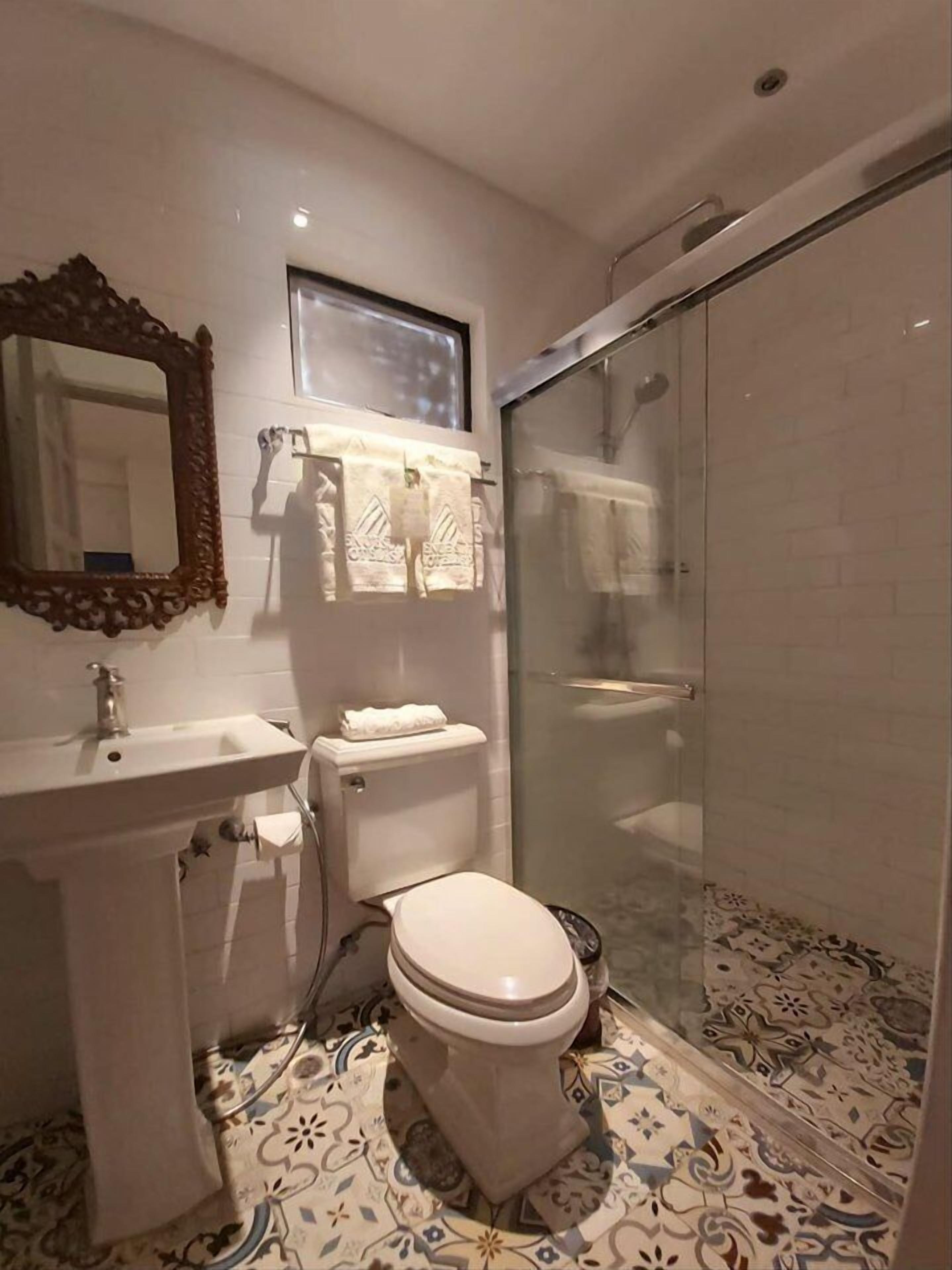 Ein Badezimmer mit Toilette, Waschbecken und Duschbereich.