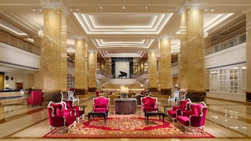 Experience the grand lobby's elegant design, featuring plush seating and a grand staircase.