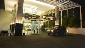 Ein modernes Gebäude mit Glasfassade und einem Parkplatz davor.
