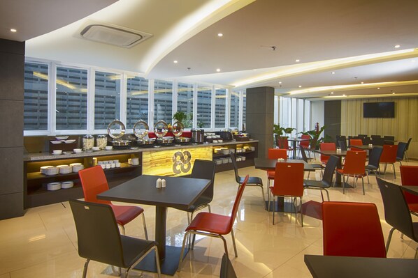 Un restaurante moderno con zona de bar, diversas opciones de asientos y amplios ventanales con vistas a la ciudad.