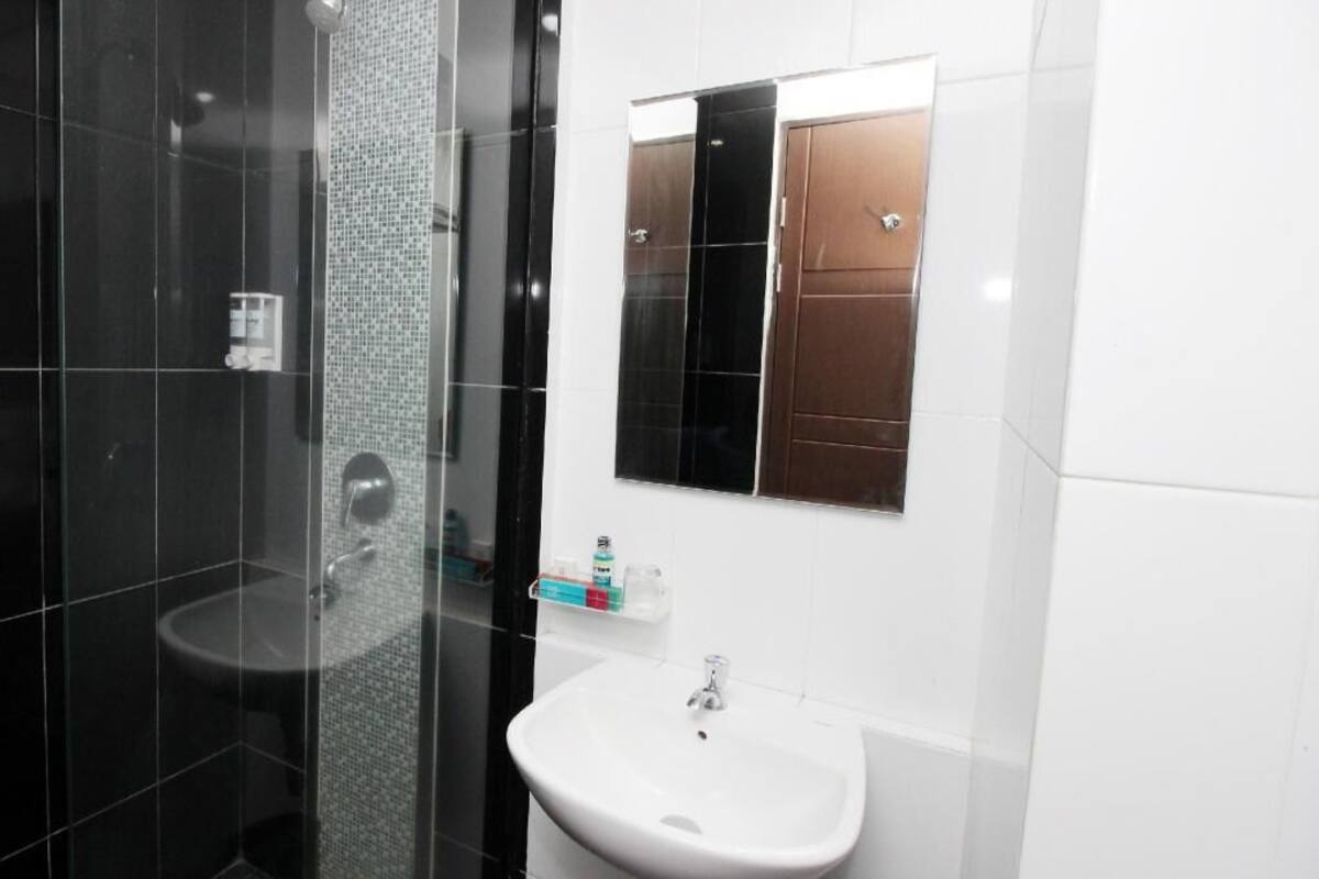 Une salle de bain avec une douche à parois de verre, un lavabo et un miroir.