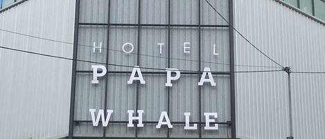 A building with a sign that reads "HOTEL PAPA WHALE".