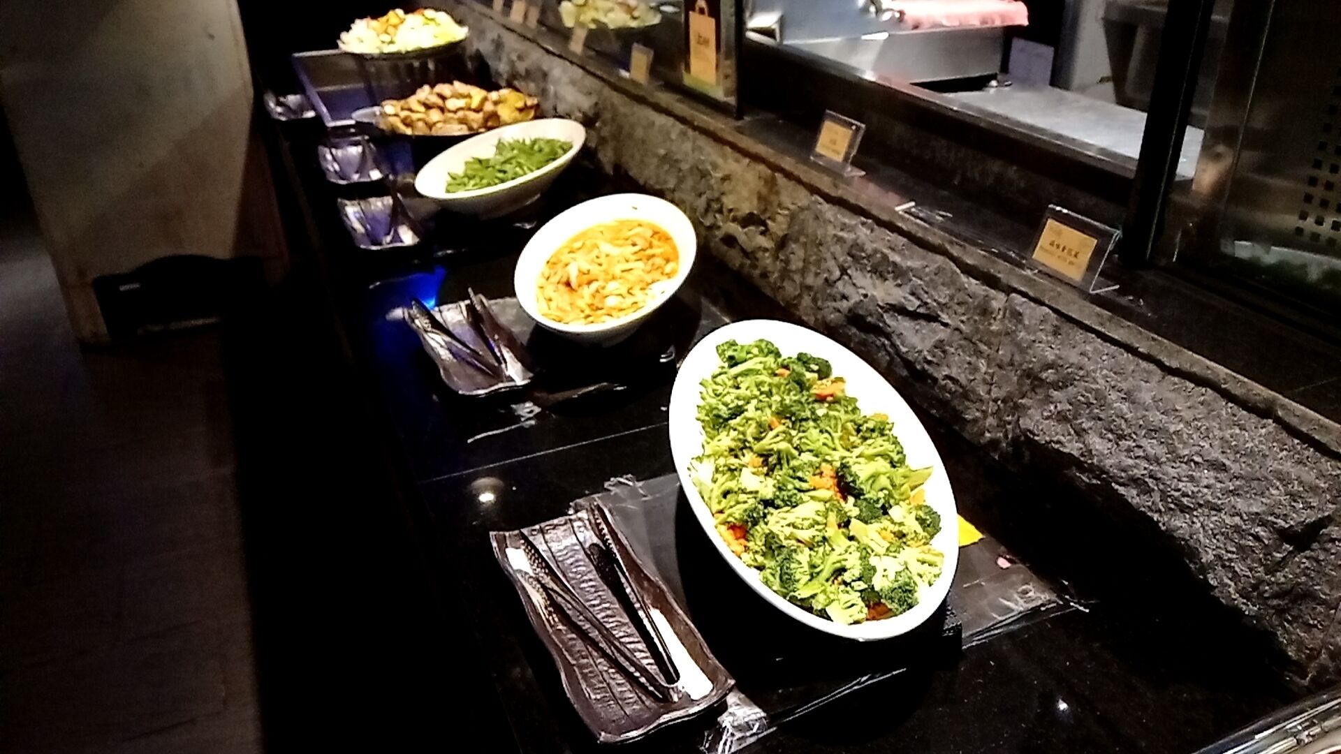 A buffet with various dishes including pasta, vegetables, and other prepared foods.