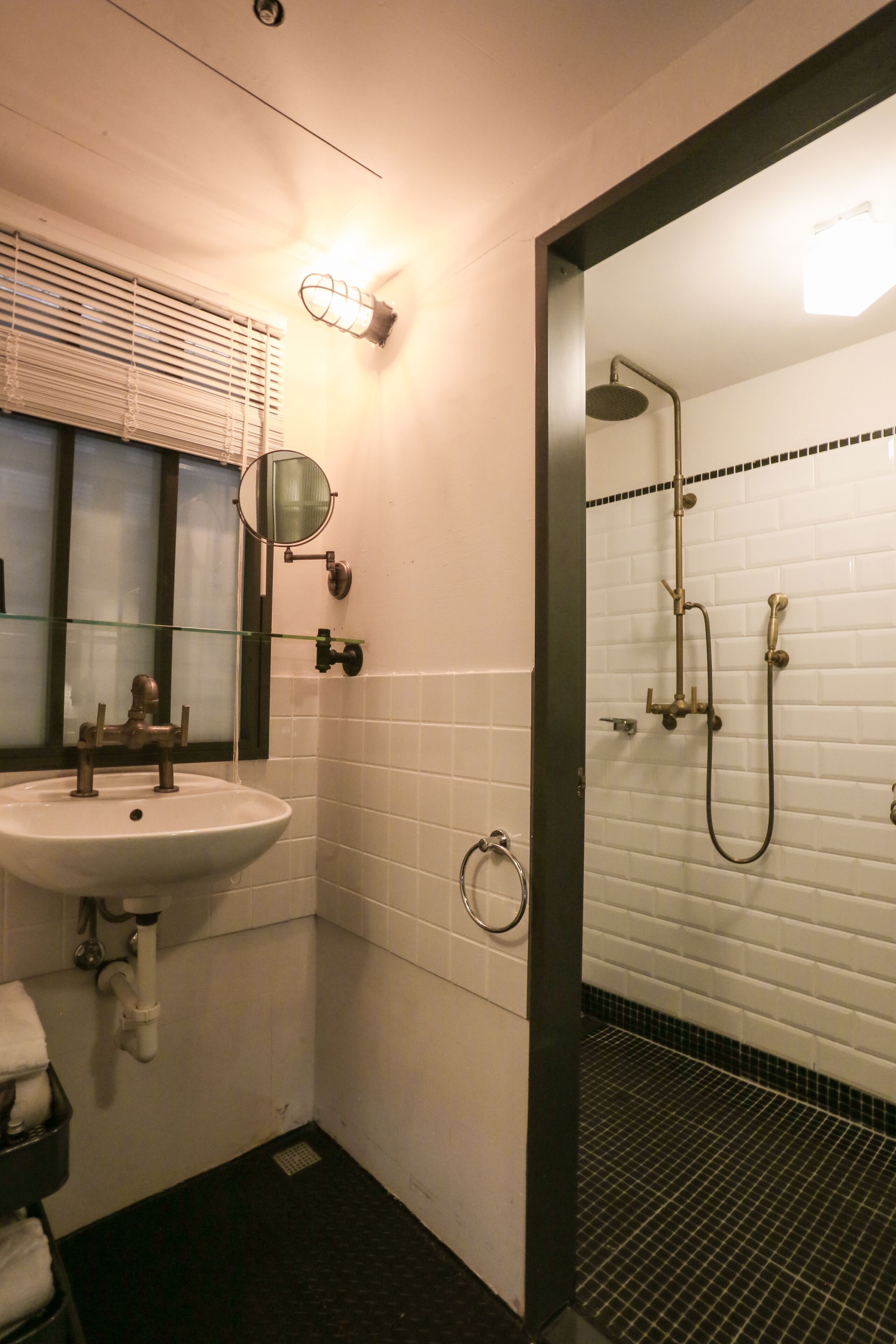A bathroom with a sink, mirror, and shower.
