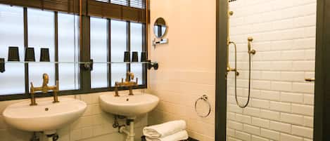 Baño con dos lavamanos, un espejo y una ducha.