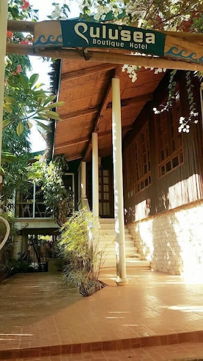 A wooden building with a sign reading "Qulusea Boutique Hotel".
