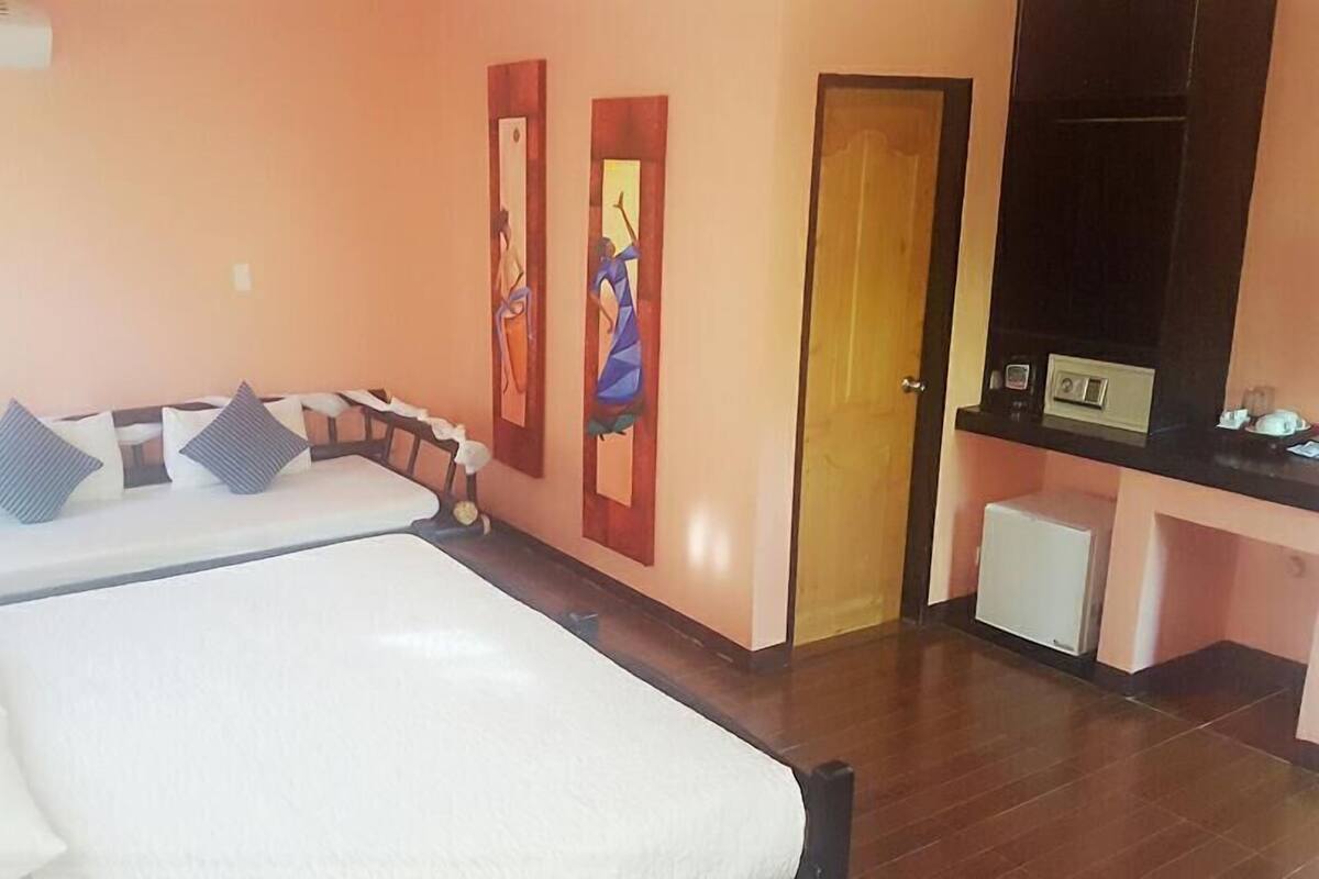 Une chambre d’hôtel avec un lit, un petit bureau et une porte.