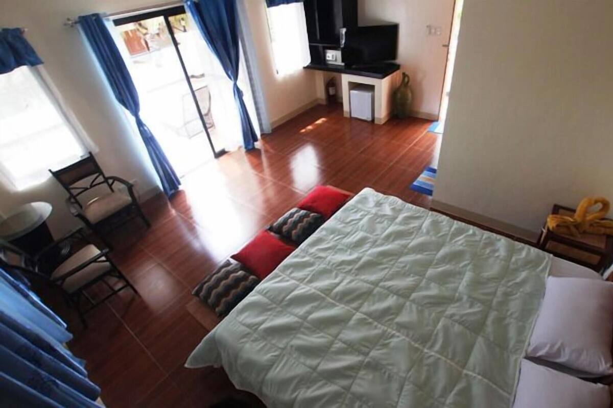 Une chambre avec un lit, une télévision, un bureau et une chaise.