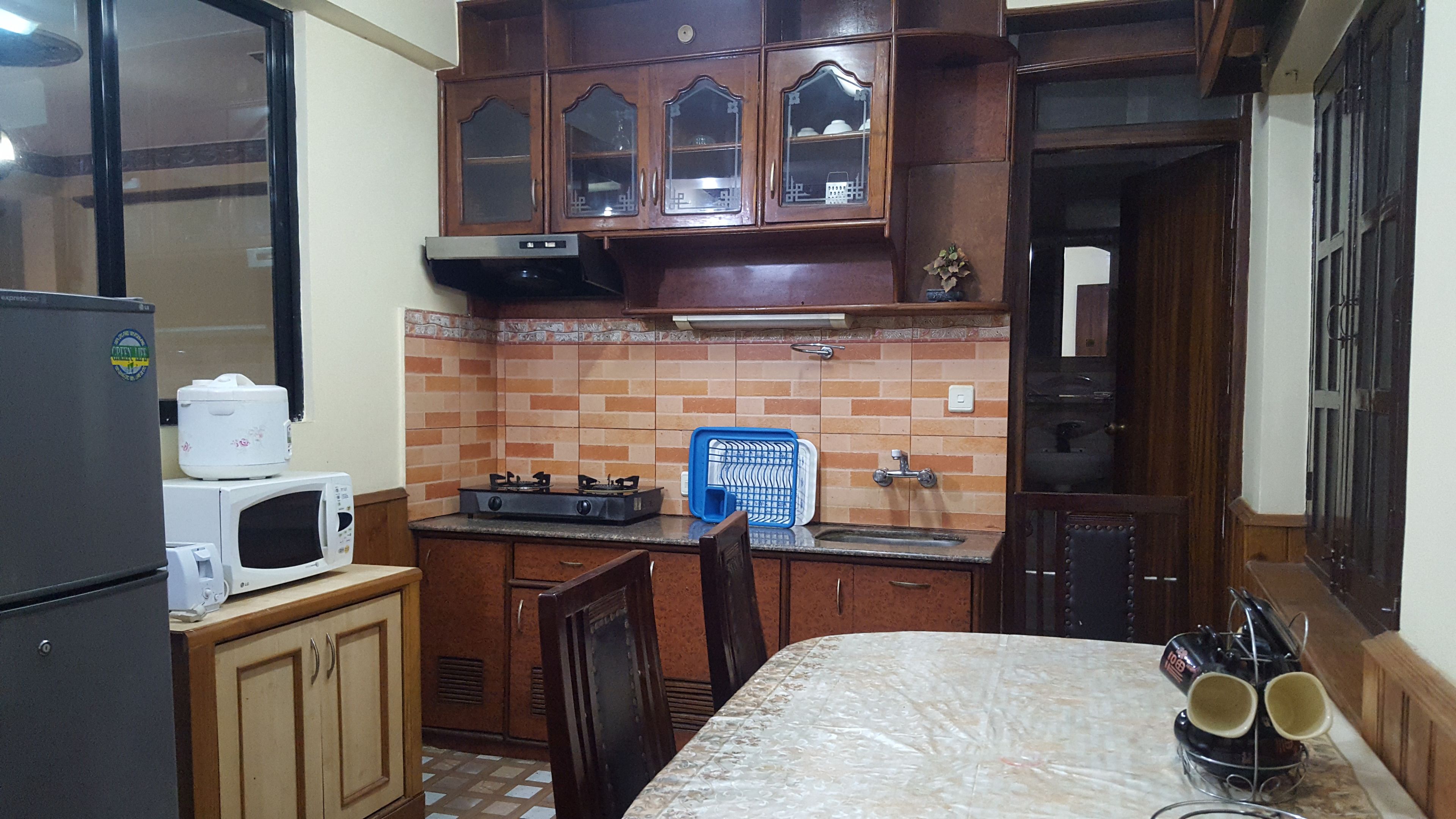 A compact kitchen with a microwave, stove, and cabinets.