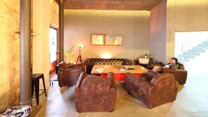 Un amplio salón con sofás y sillones de cuero dispuestos alrededor de una mesa central.