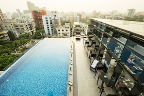 A rooftop pool with a dining area and city views. - THE WAY Dhaka (Dhaka)