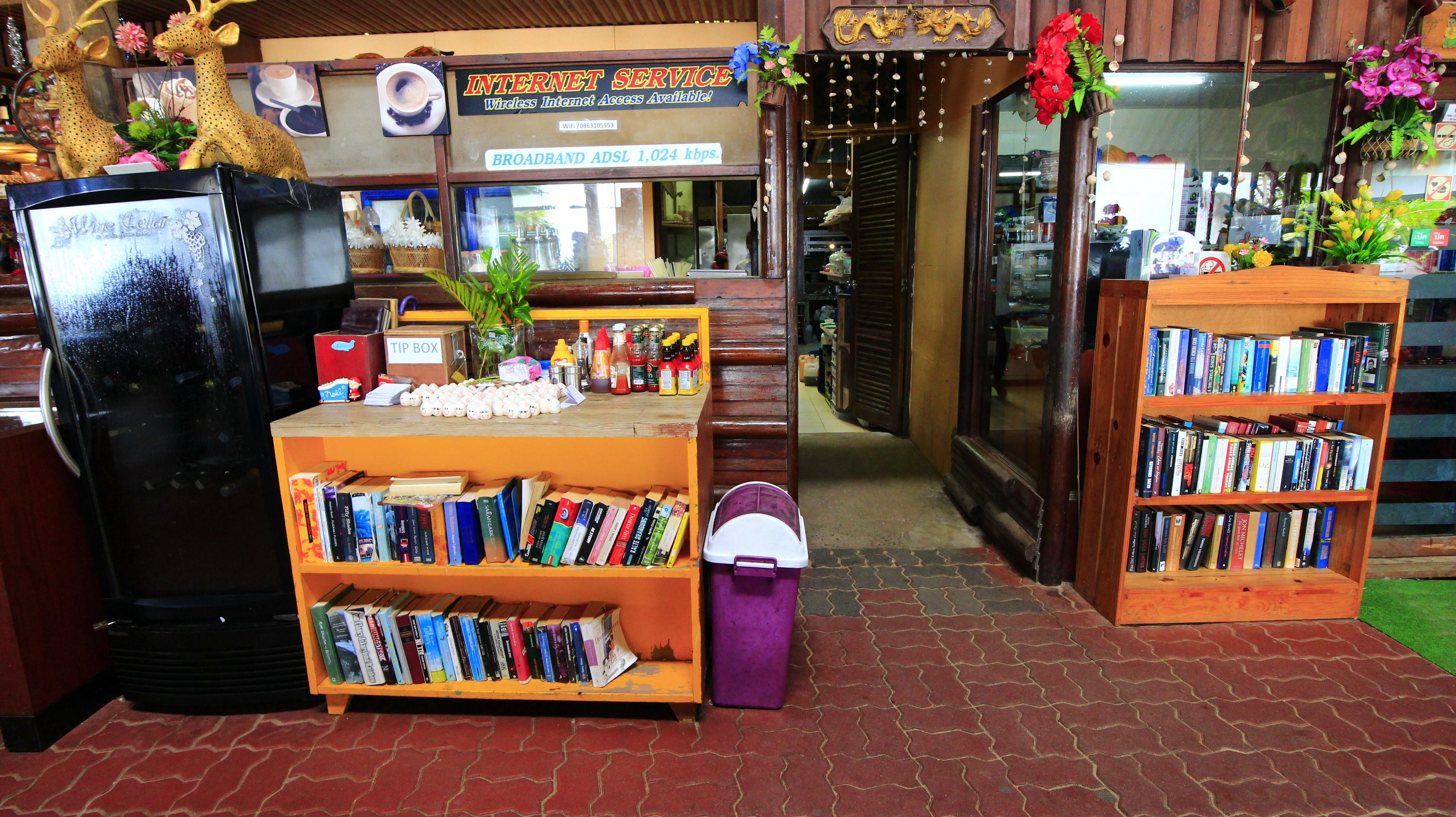 A bookstore with a variety of bookshelves, a tip box, and a refrigerator.