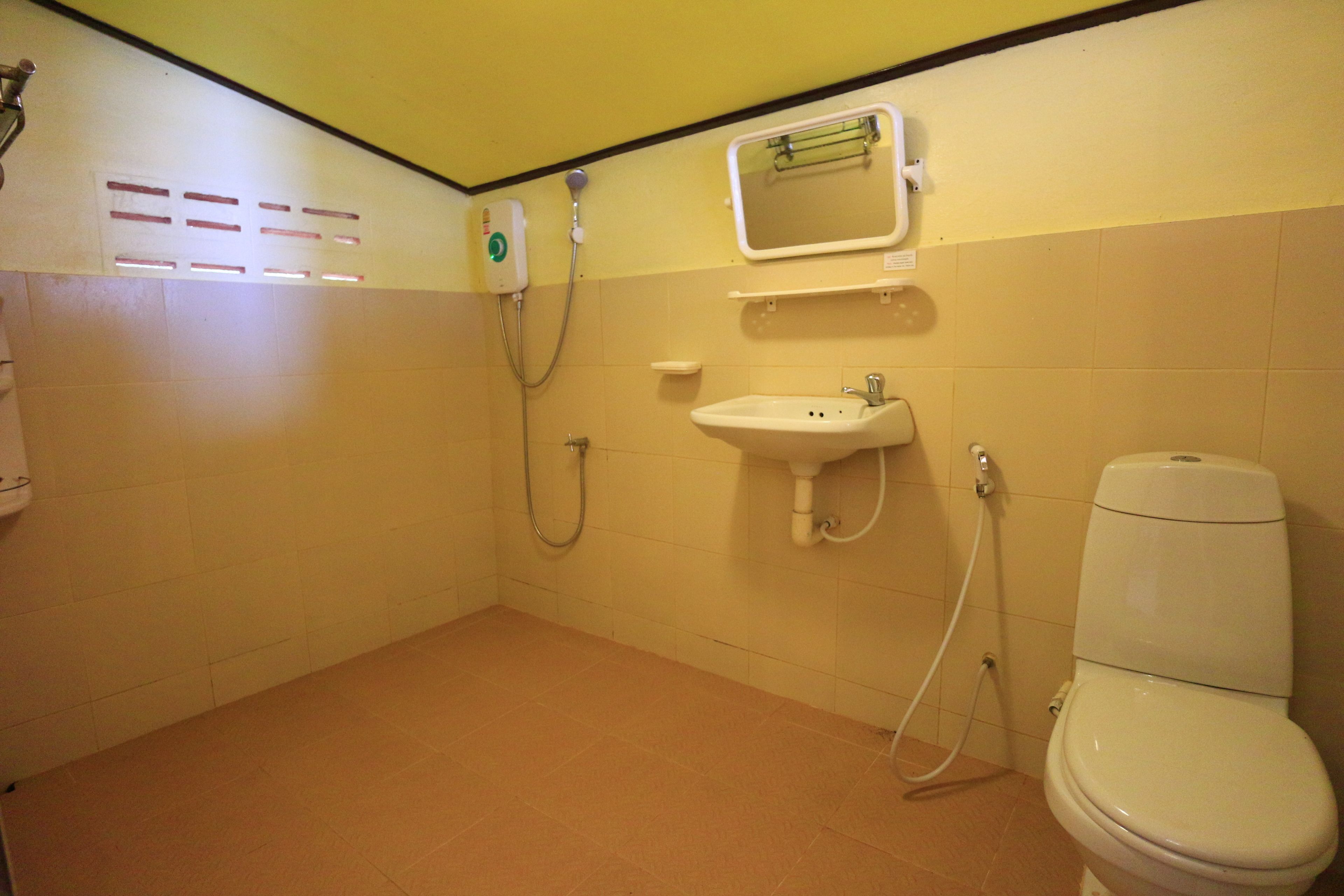 Un baño pequeño y limpio con inodoro, lavamanos y ducha.