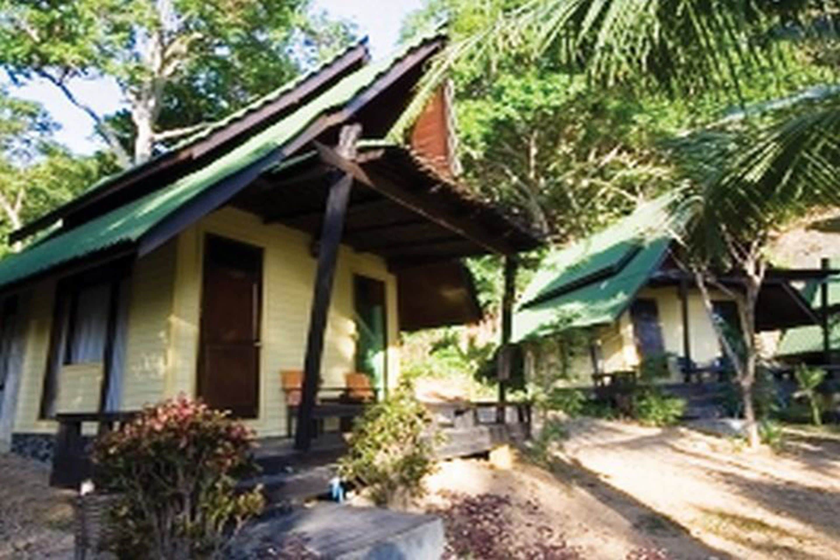 A two-story building with a green roof and a porch.