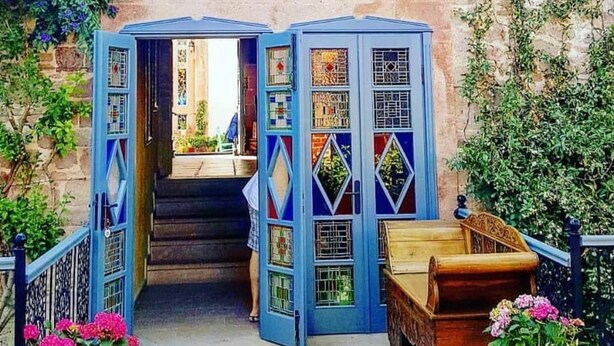 A two-story building with a blue facade and a central staircase. - Ziyabey Konagi (Ayvalik)