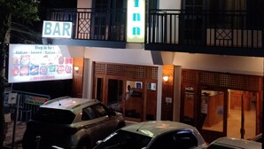 A multi-story building with a prominent sign for "Greenwoods Inn" and a "BAR" sign below. - Greenwoods Inn (Dharamshala)