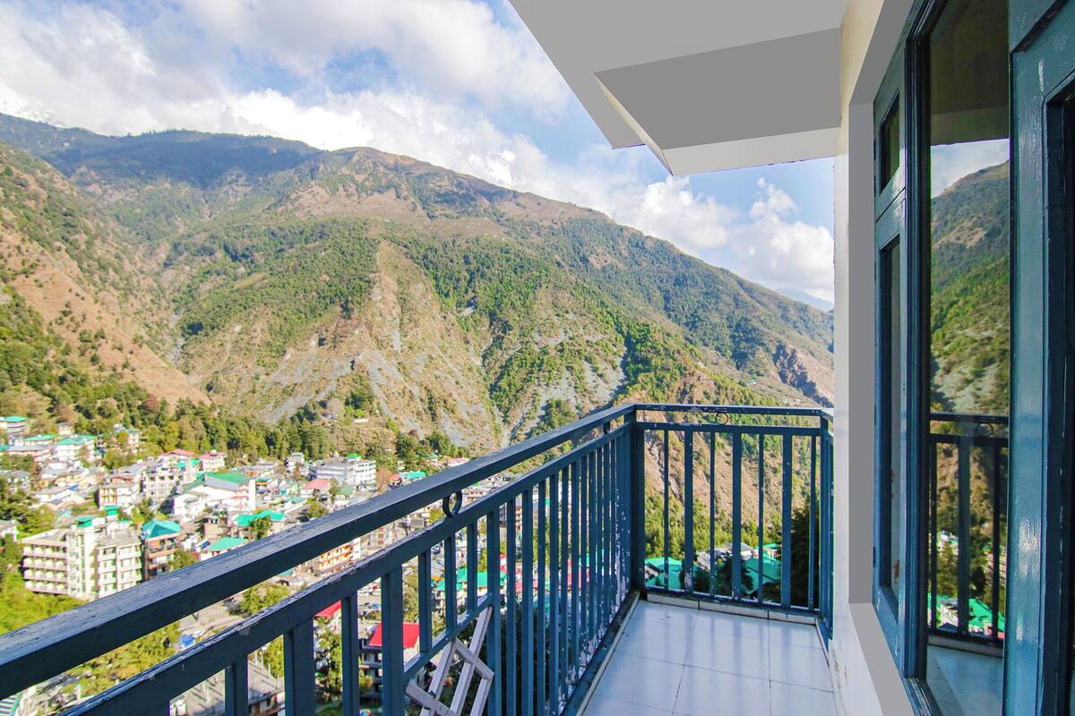 Un balcón con vistas a un paisaje montañoso y un pueblo abajo.