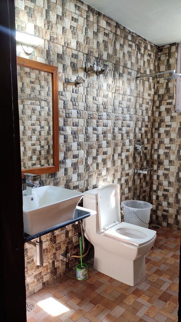 A bathroom with a mosaic tile wall, a bathtub, a toilet, and a shower. - Greenwoods Inn (Dharamshala)