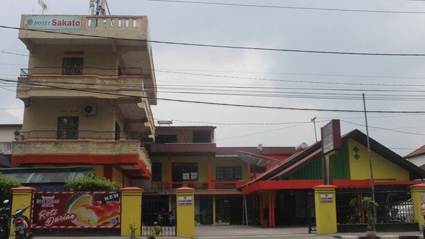 A hotel named "Sakato" with a prominent sign, a balcony, and a visible entrance gate. - Hotel Sakato (Bukittinggi)